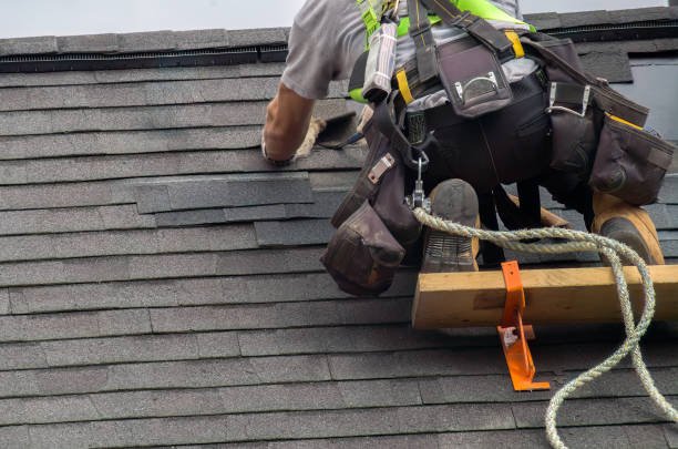 A man securing himself with a rope while working on an affordable roof installation in South Bend IN