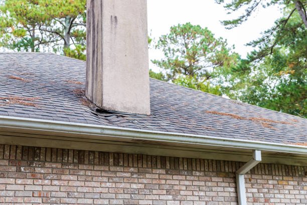 A man works on a brick chimney, addressing leaks as part of a chimney repair project.