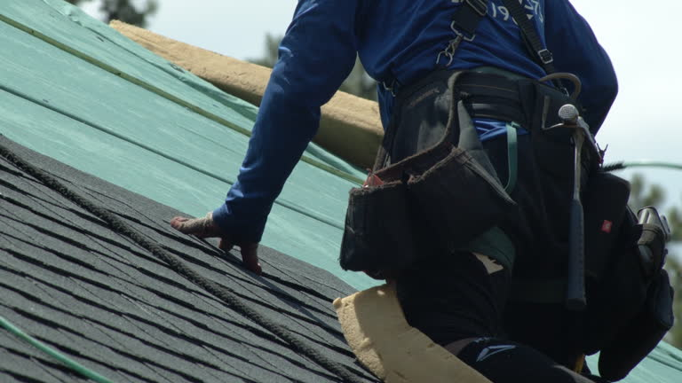 A man wearing a hard hat and safety vest examines a house's gutter, showcasing the work of Residential Roofing Experts.