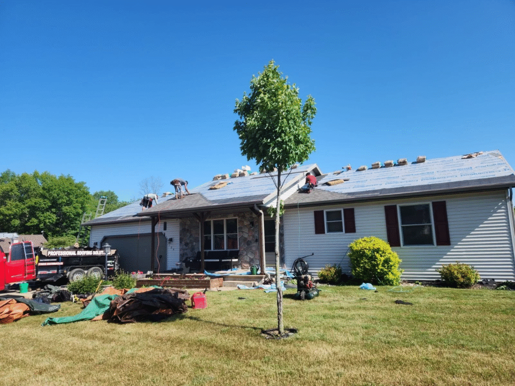 Several men engaged in roof installation, working together to secure materials and complete the project.