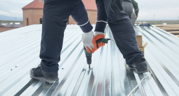 A man uses a drill to secure a metal roof, showcasing the installation of metal roofing.