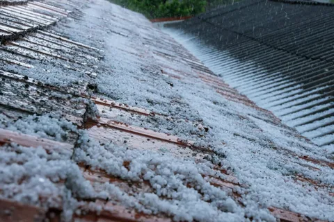 Hail damage roof shingles showing cracks and dents from storm