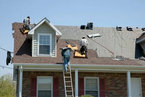Professional roofing contractors installing new shingles during a commercial roof replacement project